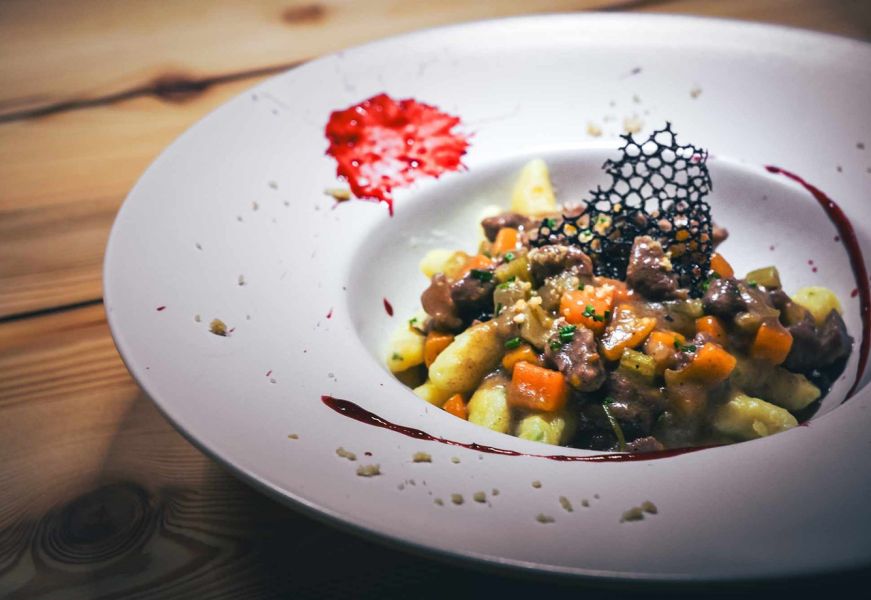 Gnocchi fatti in casa con ragù di selvaggina su piatto elegante