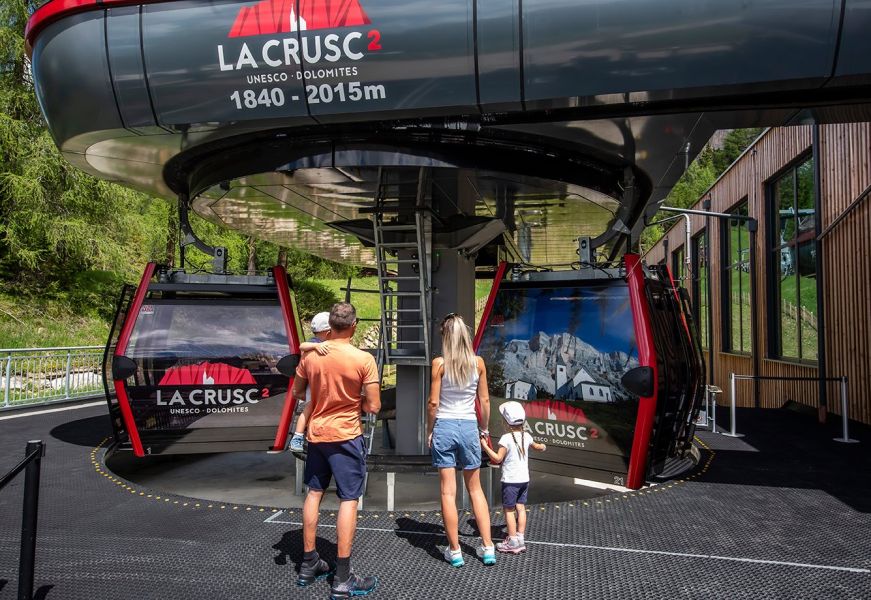 Famiglia davanti alla cabinovia La Crusc 2 in Alta Badia