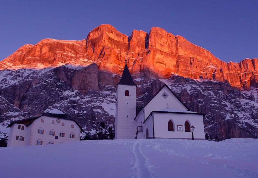 Chiesa di Santa Croce al tramonto con le Dolomiti rosate