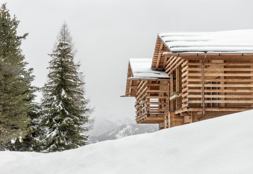 Chalet in legno tra gli alberi innevati